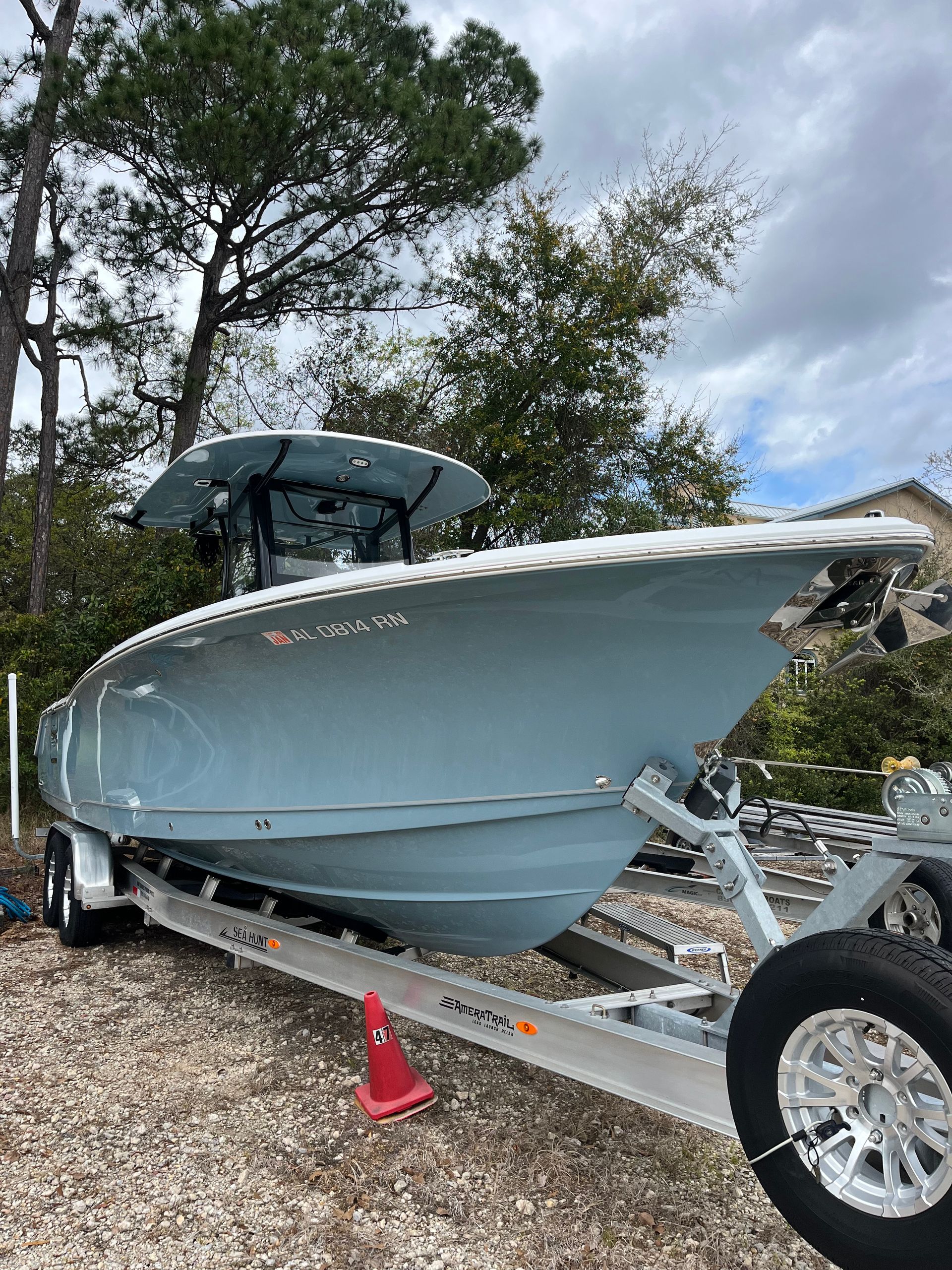 Person wearing gloves polishing a shiny, dark gray car.