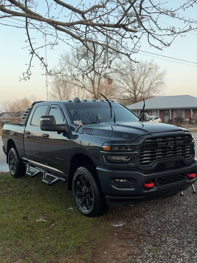 Dark gray Ram pickup truck parked on green grass; residential setting.