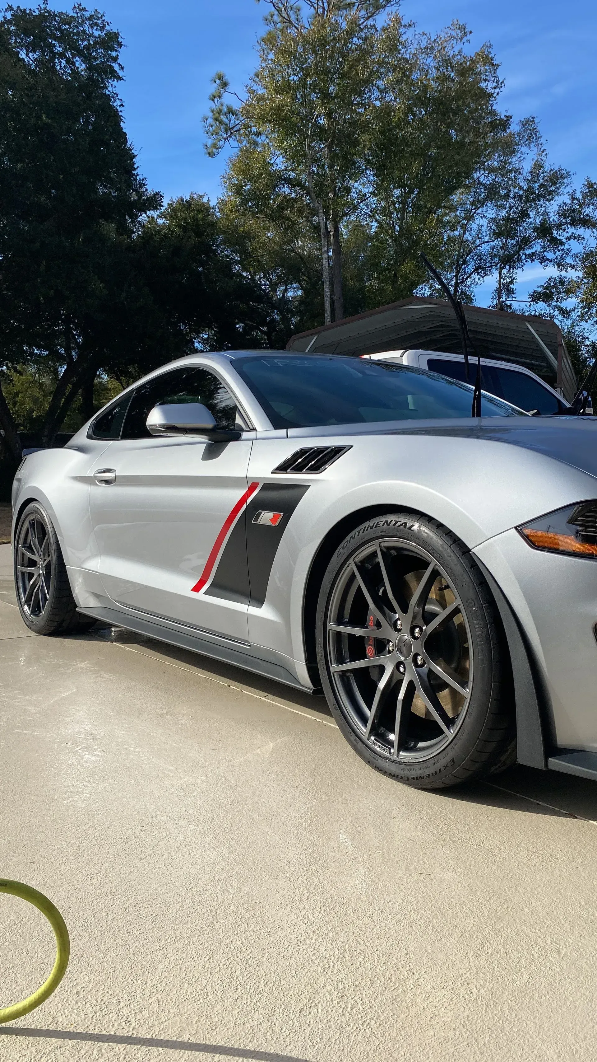A silver Ford Mustang Shelby GT350 parked outdoors on a bright, sunny day.