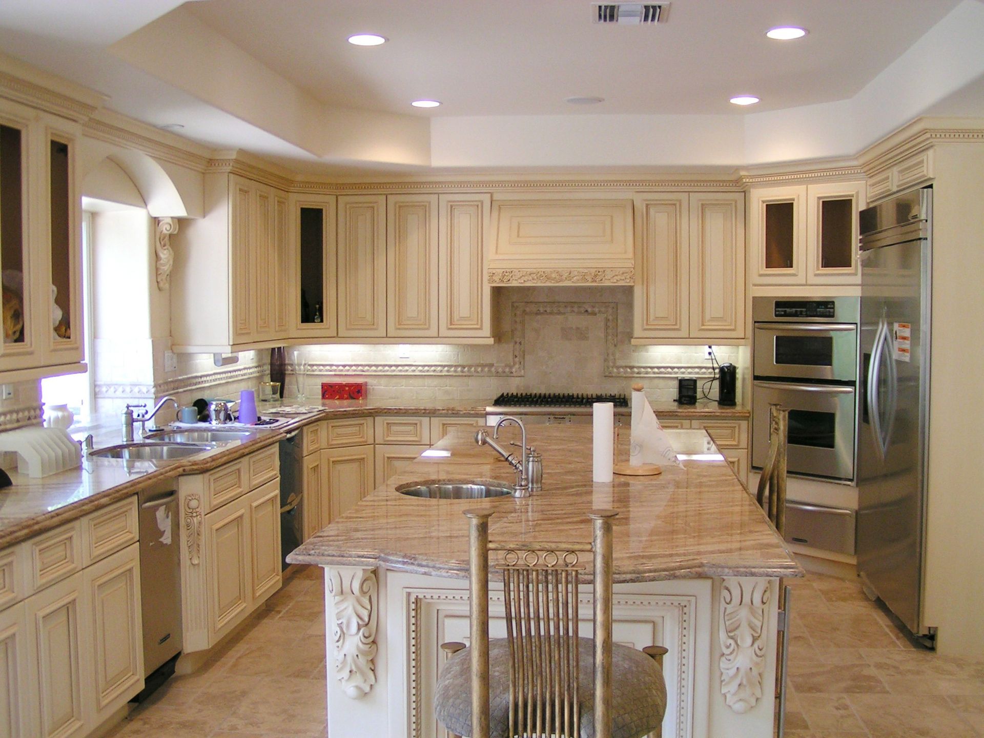 Luxury kitchen with light beige cabinets, granite countertops, and stainless steel appliances.