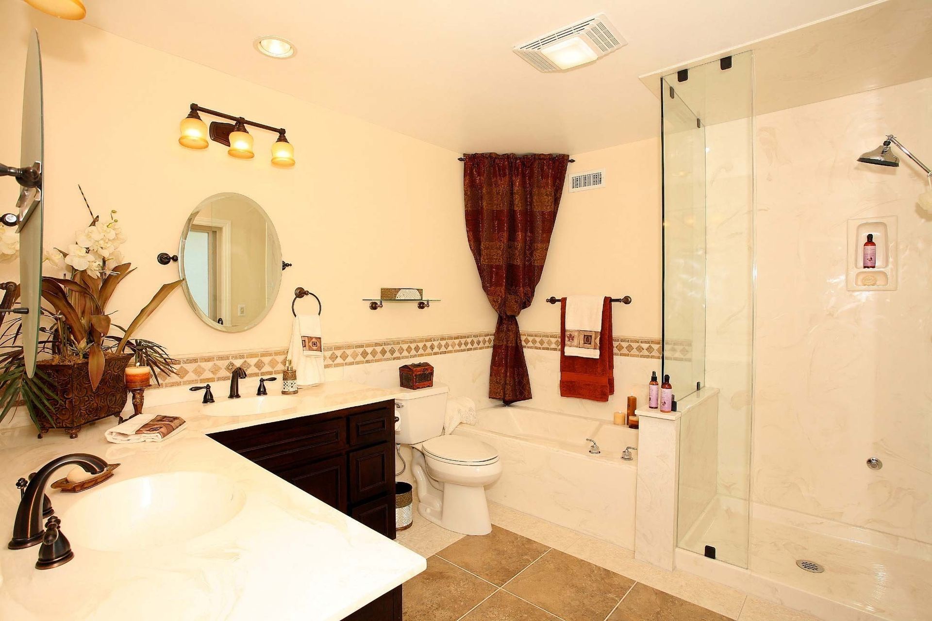 Bathroom with white marble, dark vanity, glass shower, and brown accents.