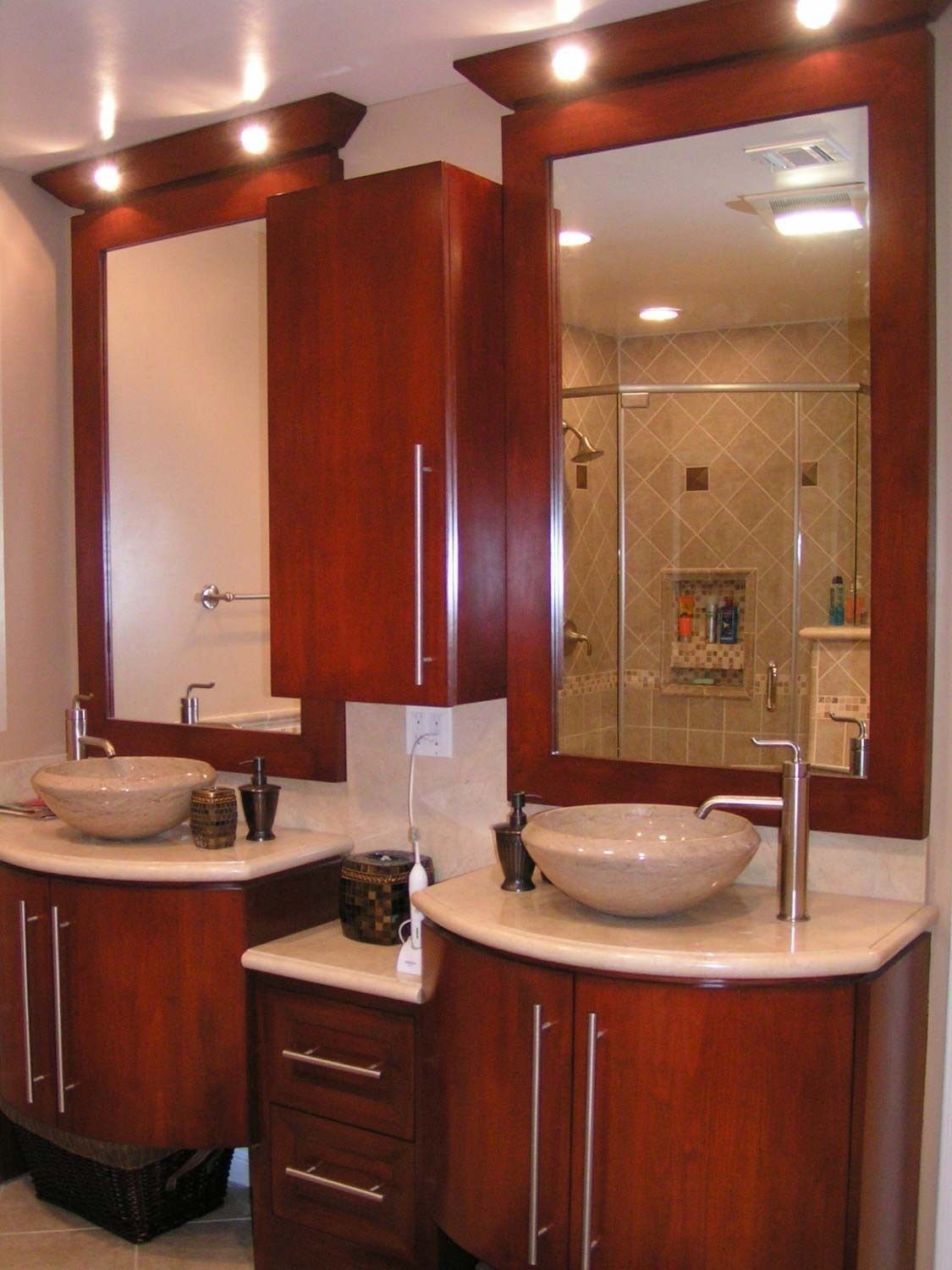 Two bathroom vanities with wood cabinets, vessel sinks, and mirrors.