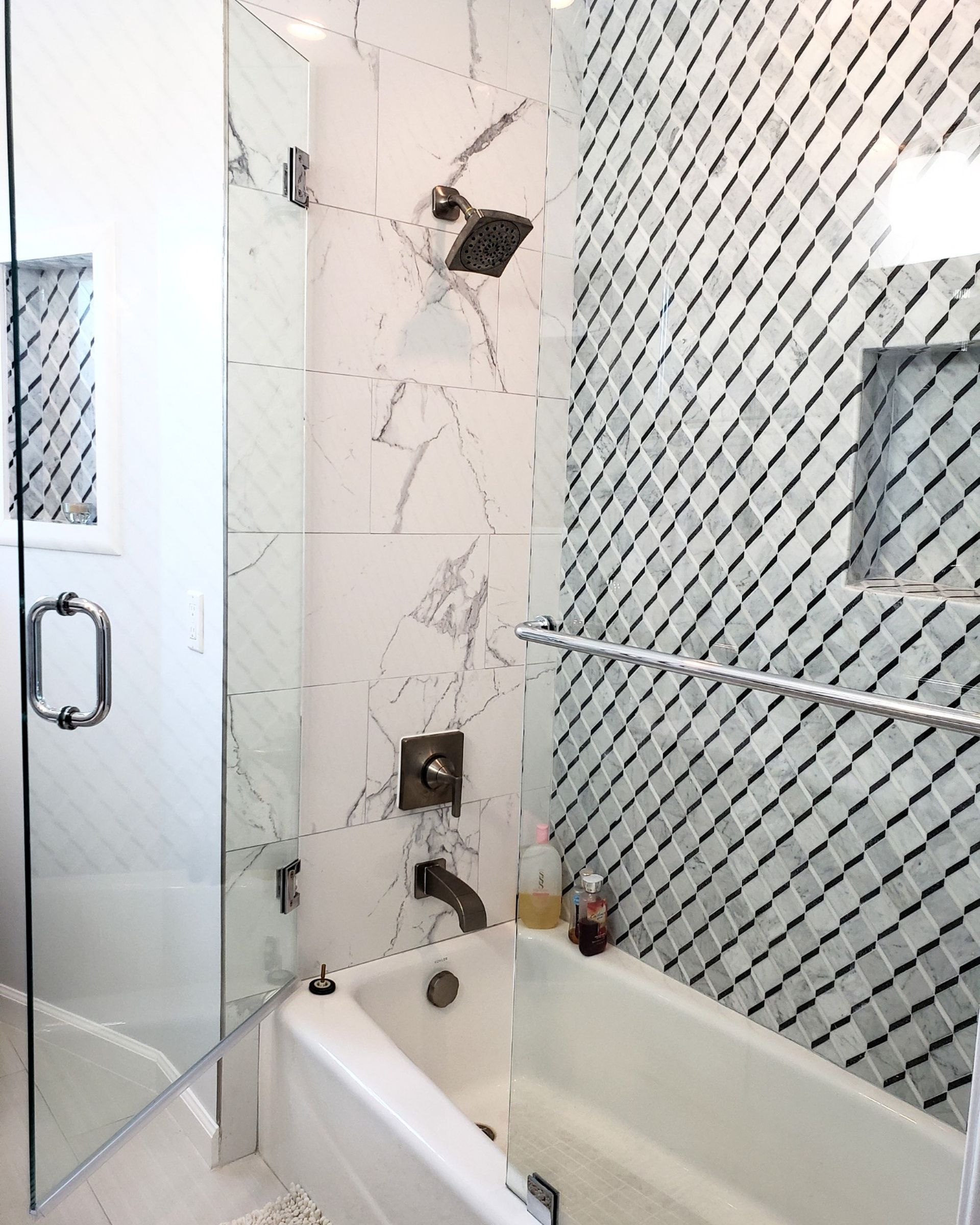 Modern bathroom with a glass shower enclosure and a white bathtub.