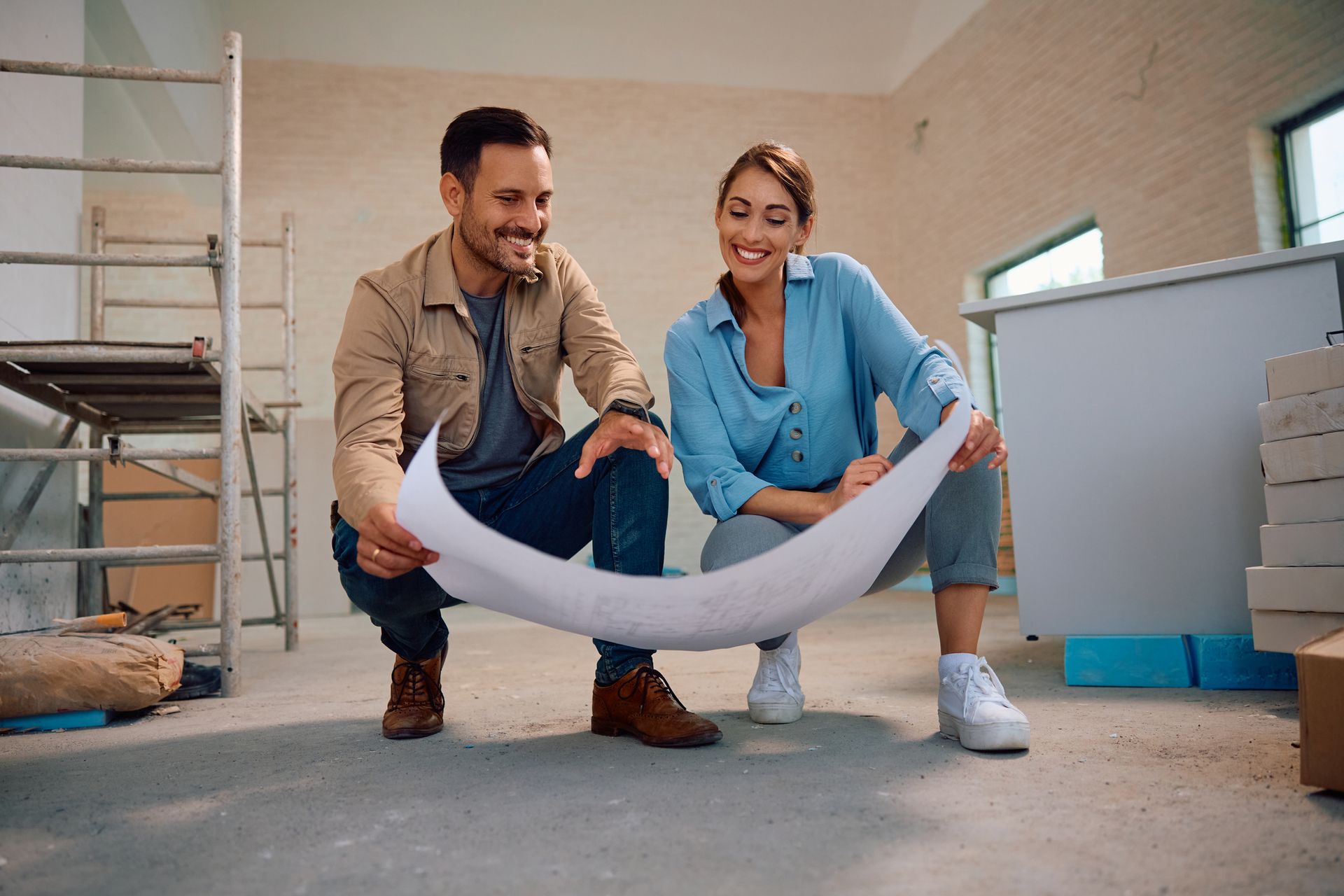 Happy couple reviewing kitchen and bathroom remodeling plans during spring home renovation.