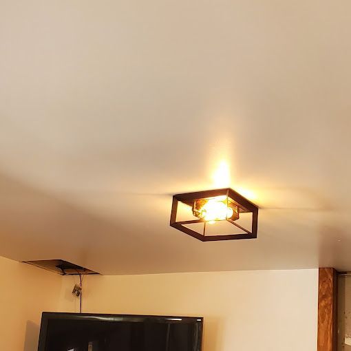 A ceiling light is hanging from the ceiling in a living room.