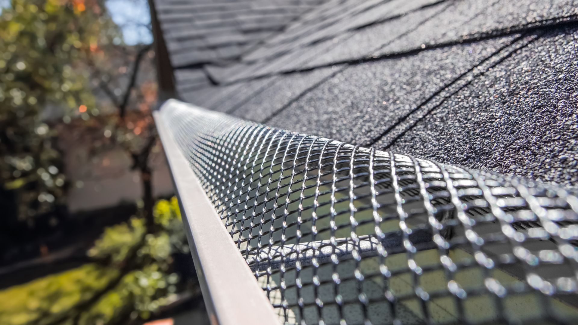 A close up of a gutter with a gutter guard on it.