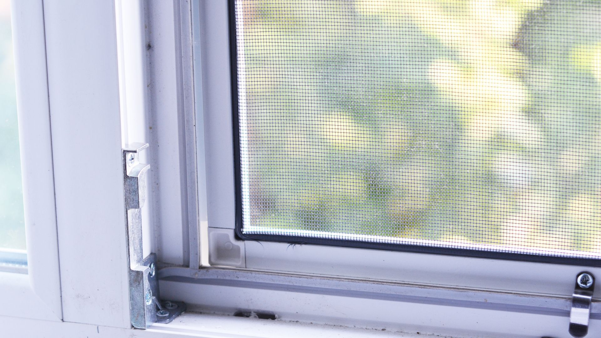 A close up of a window with a screen on it.