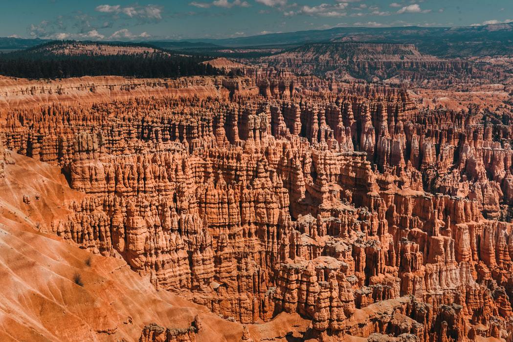 Red rock formations and hoodoos in Bryce Canyon, Utah, under a blue sky.