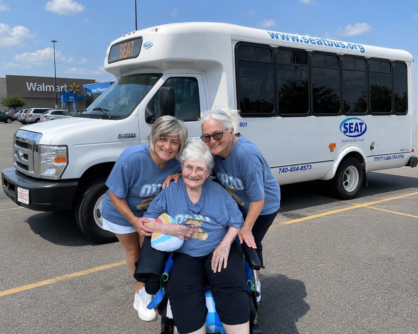 Three people (one in wheelchair) with SEAT bus