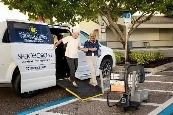 Woman helped by aide exiting Space Coast Area Transit van with ramp.