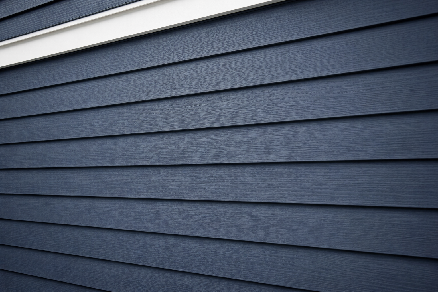 Blue horizontal siding on a building, with white trim above.