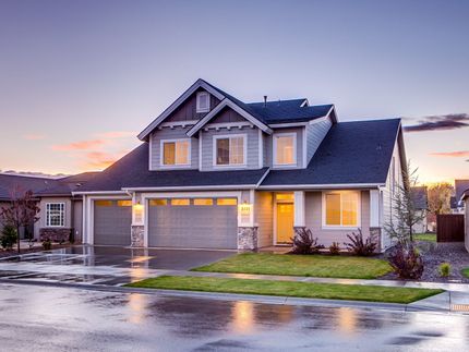 a large house with a garage and a driveway on a rainy day .
