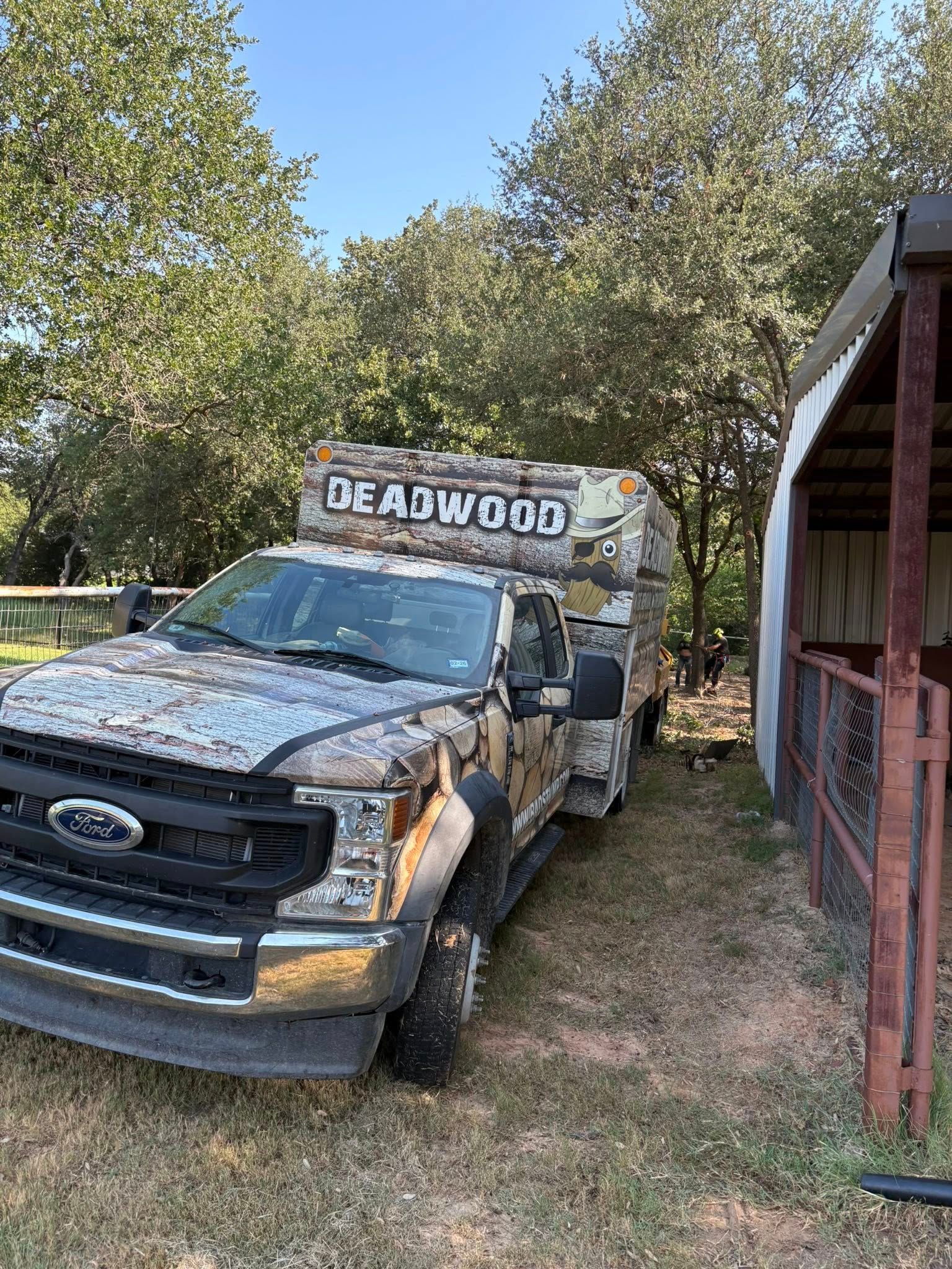 Camouflage-wrapped Ford truck pulling a trailer with 