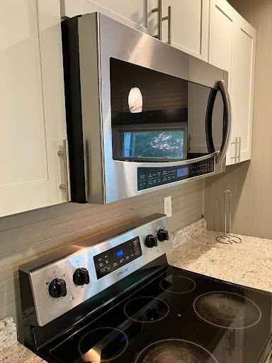 A kitchen with a stove , microwave , and refrigerator sparkling clean after commercial cleaning services boone nc