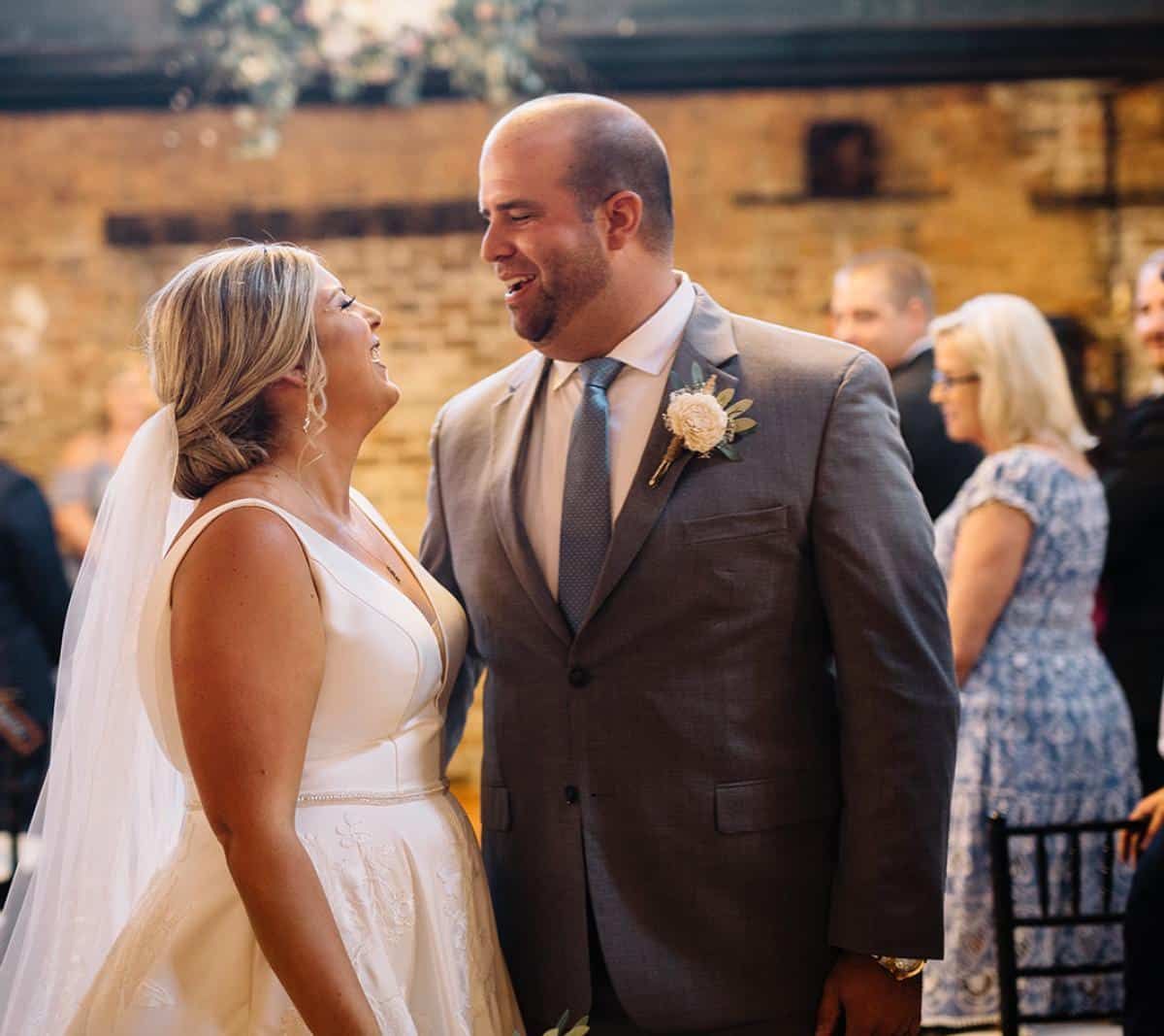 A bride and groom are looking at each other at their wedding reception.