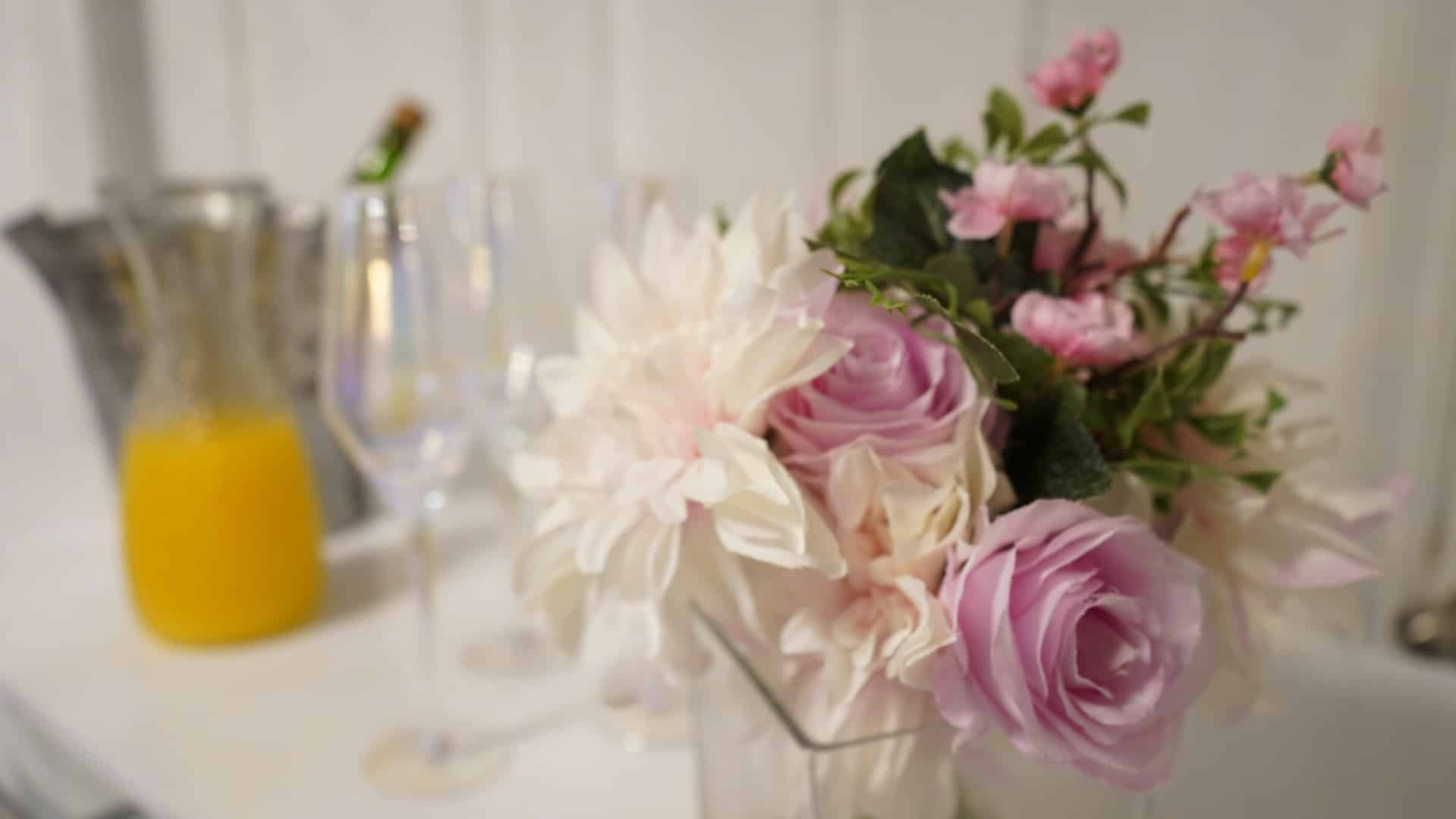 A vase filled with pink and white flowers is on a table.