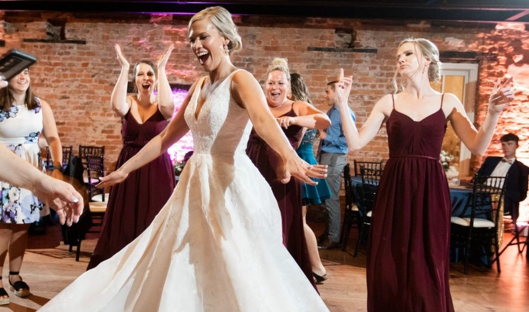 A large group of people are posing for a picture at a wedding reception.