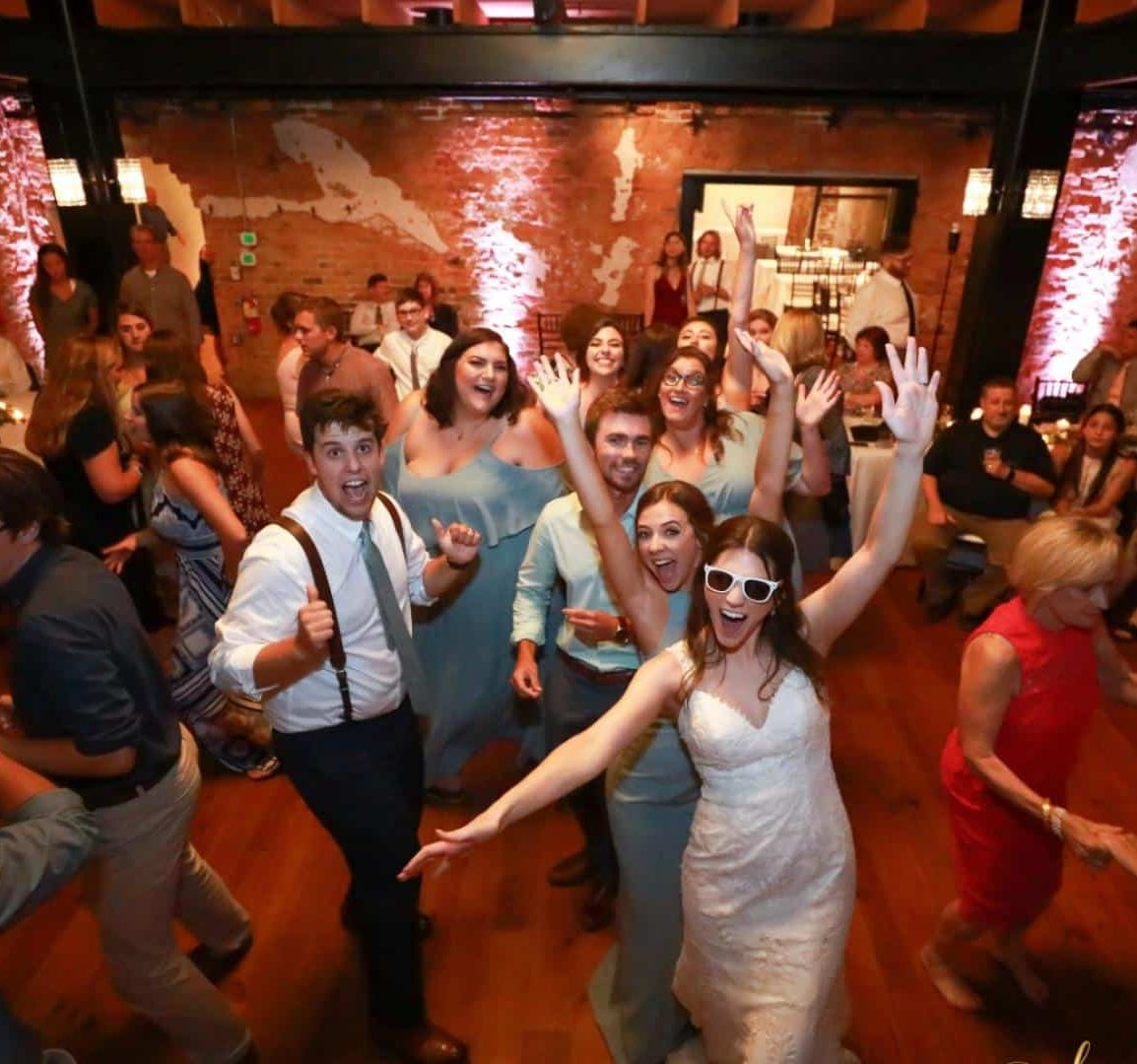 A group of people are dancing at a wedding reception