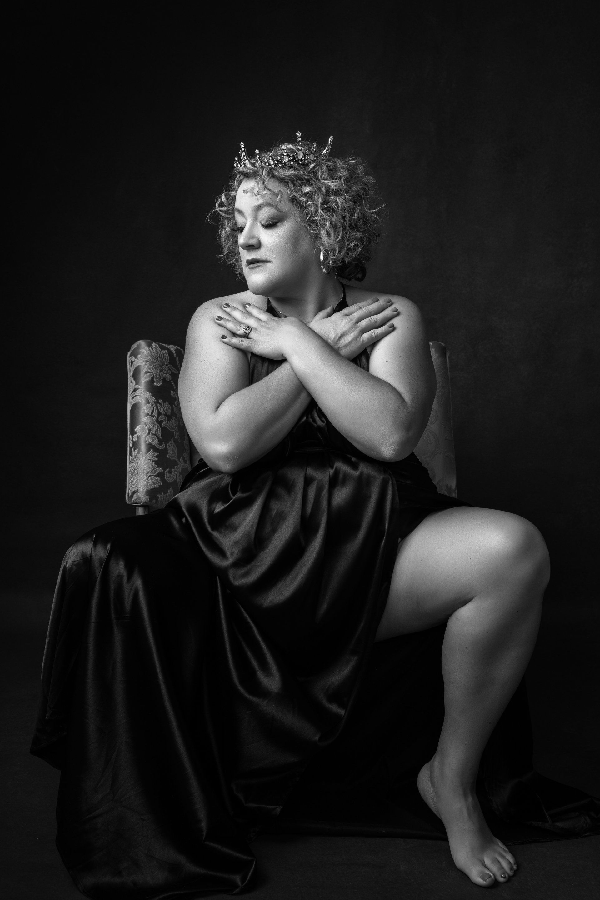 portrait of a woman wearing crown with arms crossed