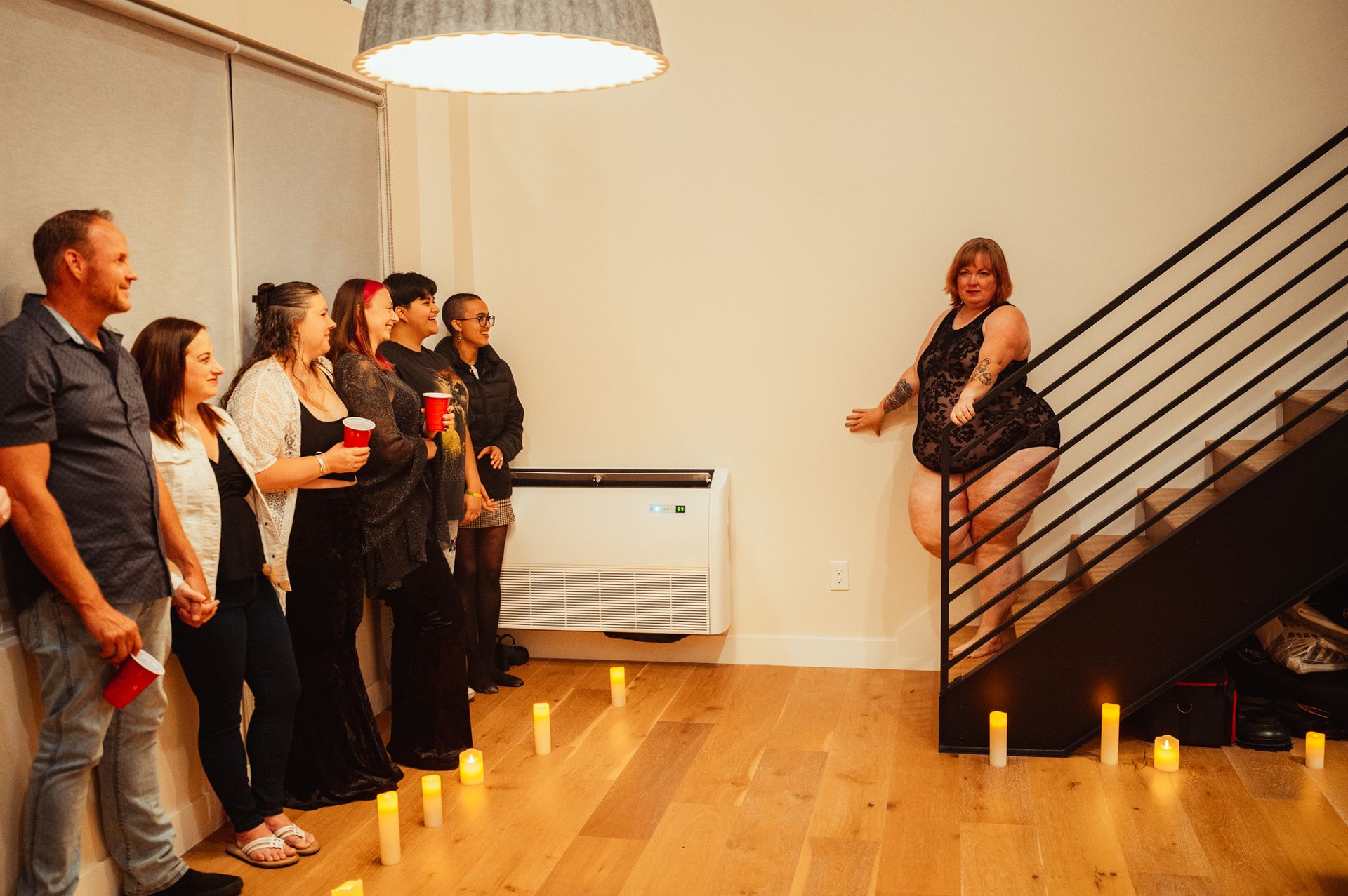 A woman in a sleek black dress ascends a staircase, highlighting her elegance and purposeful stride.