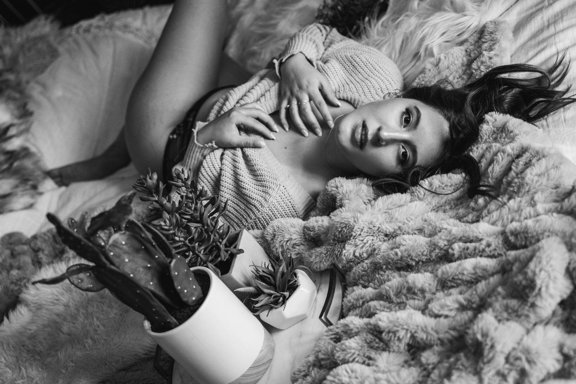 woman lying in bed with plants wearing long sleeve