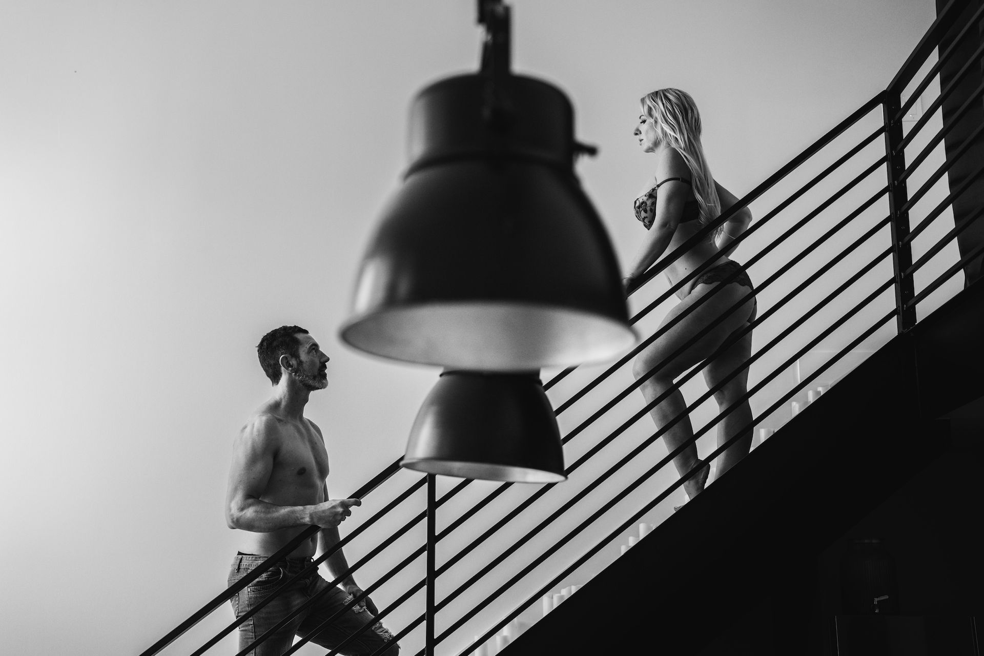 a two couple on a stair sweet to each other. Wearing pants and a lingerie