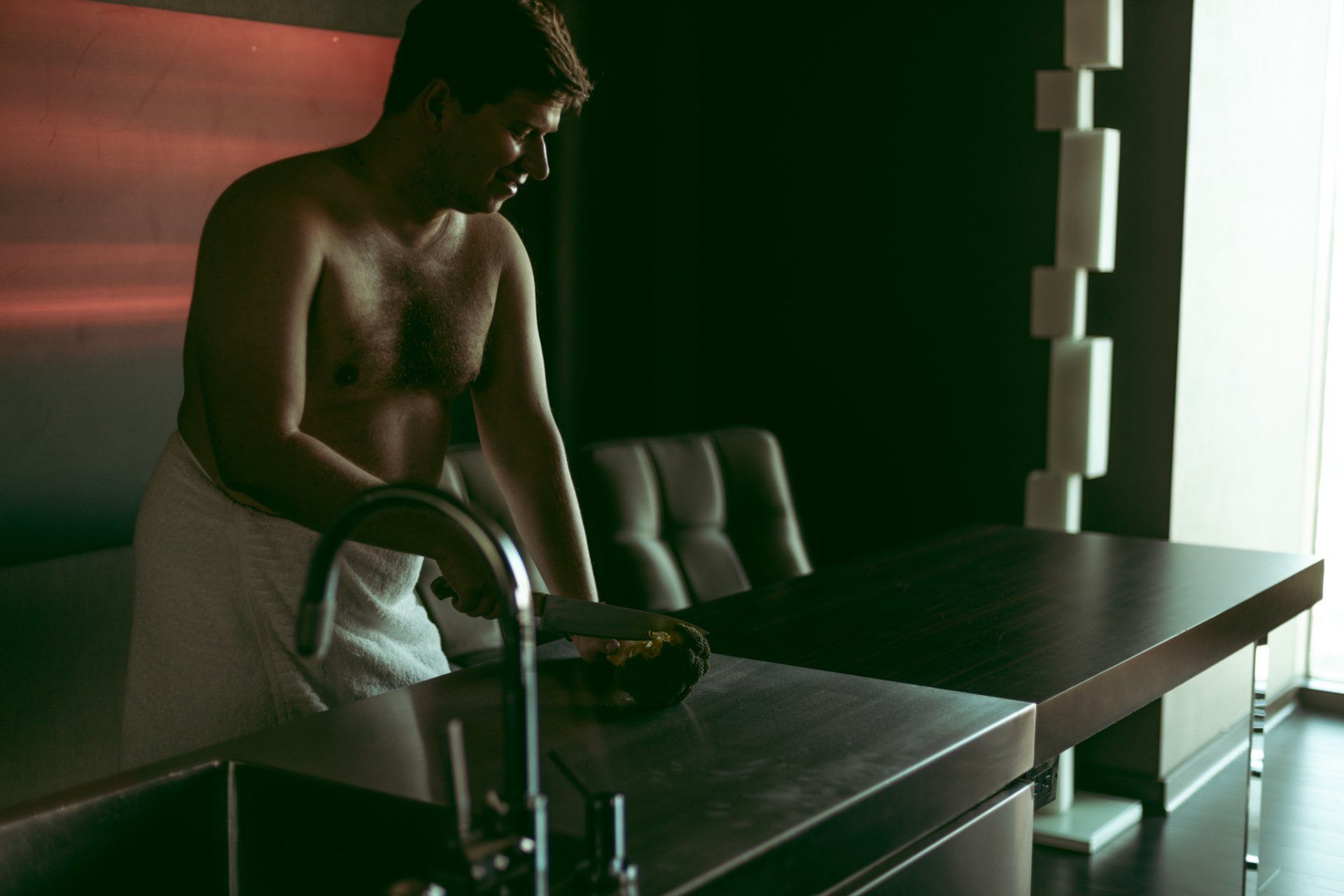 boudoir by Marco Ibanez man cutting broccoli wrapped in a towel during boudoir session