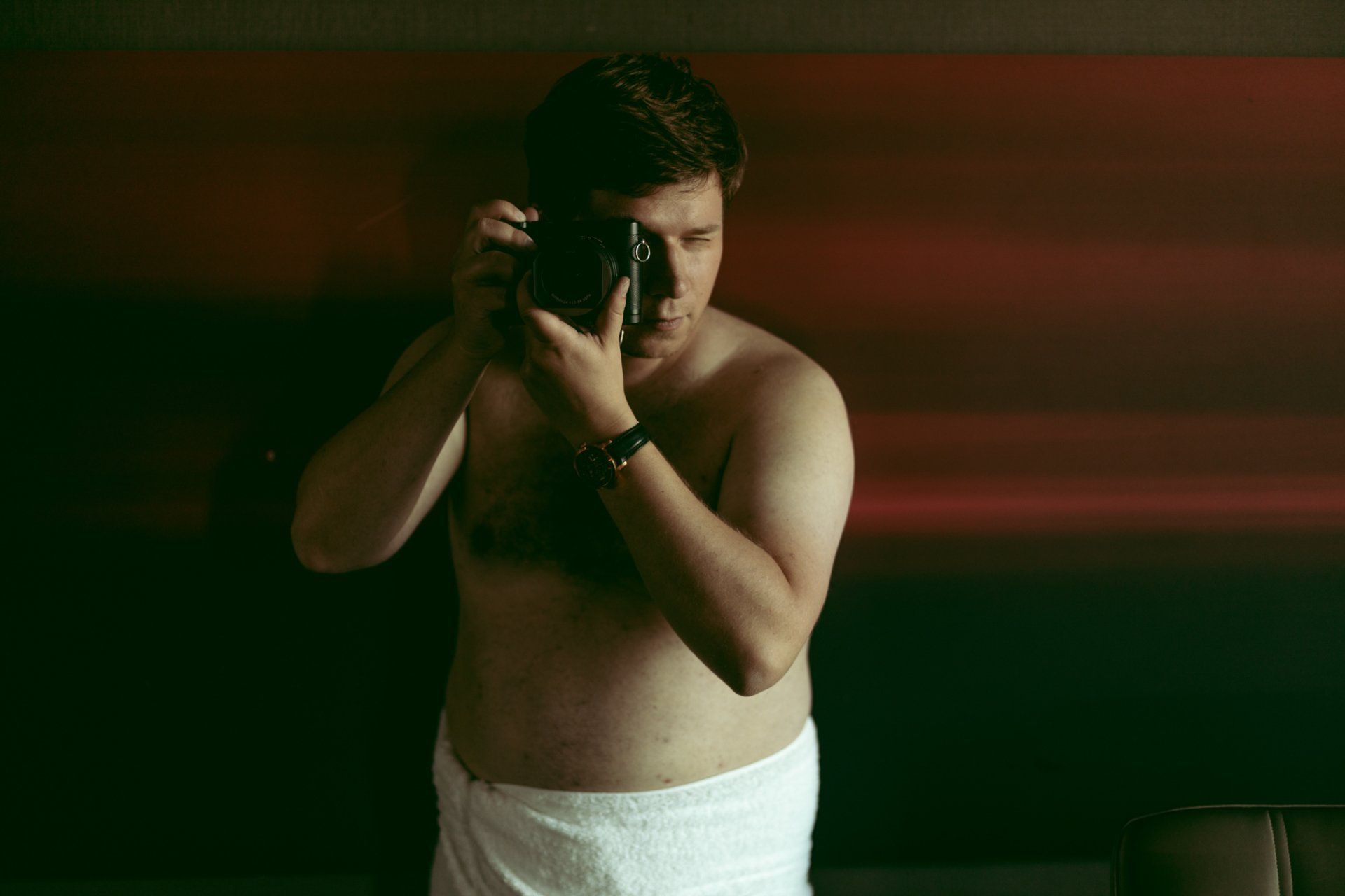 boudoir by Marco Ibanez man taking a photograph wrapped in a towel during his boudoir photoshoot