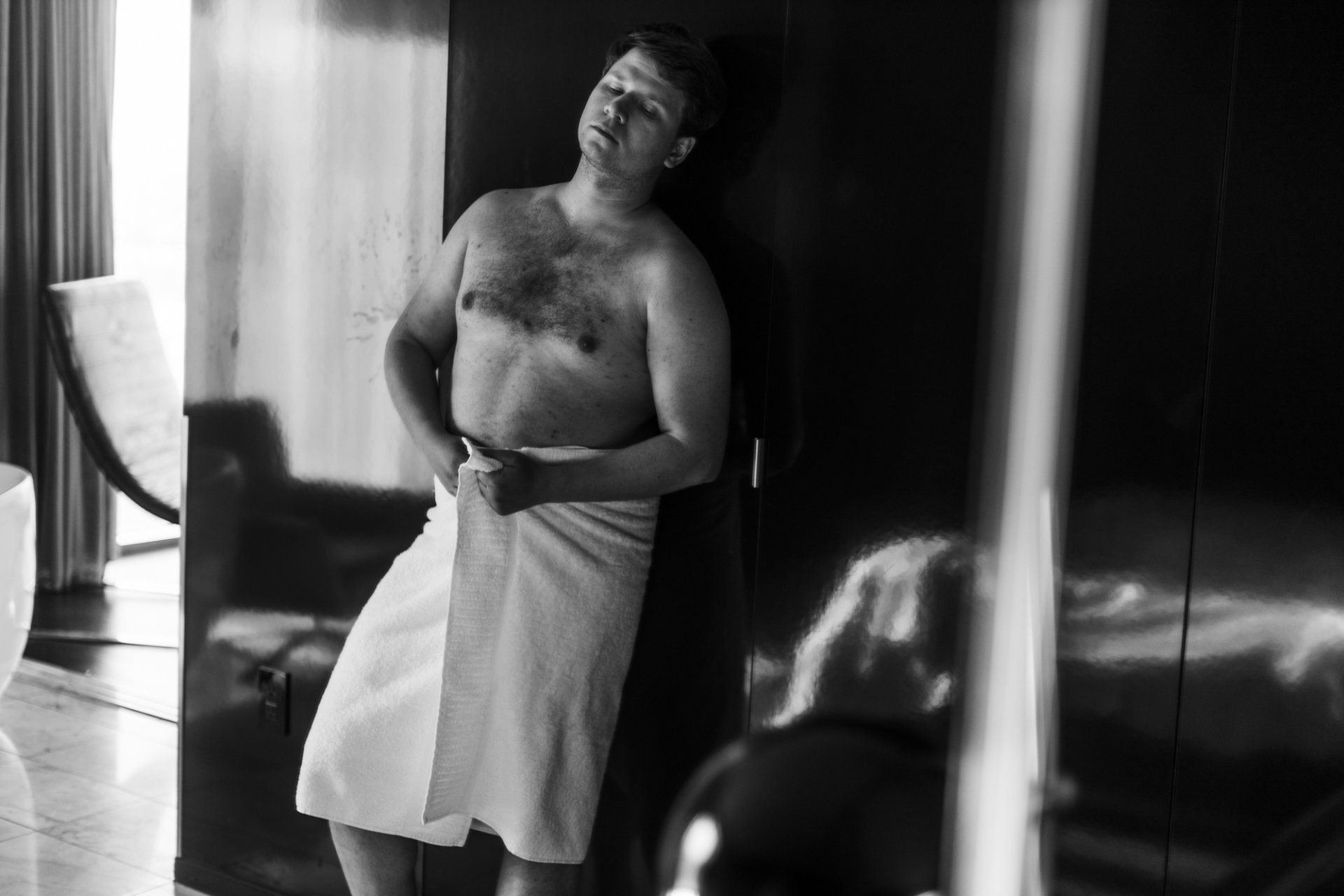 boudoir by Marco Ibanez man standing wrapped only in a towel at the boudoir experience