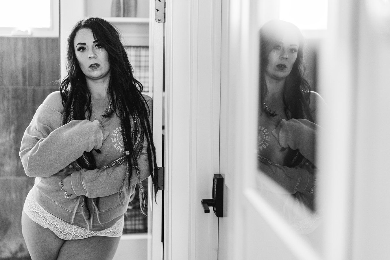 woman standing next to a mirror and posing during her boudoir session in Ogden Utah