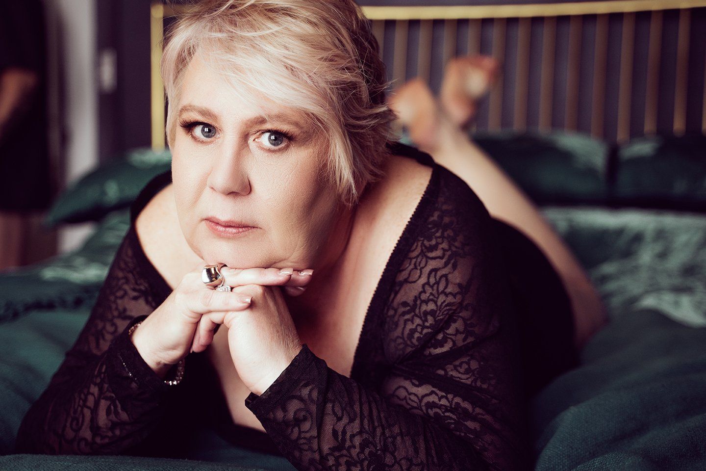 boudoir portrait of a woman on a bed, head resting on her hands