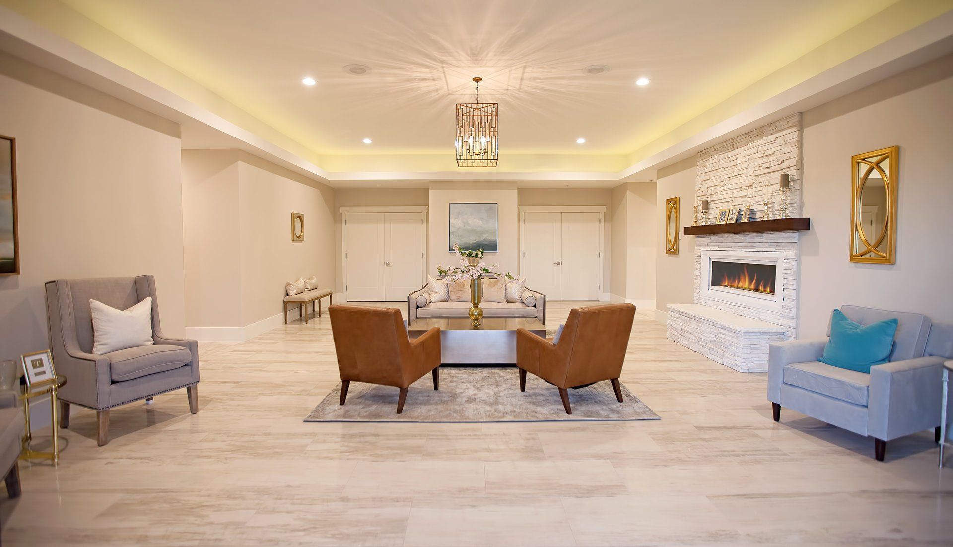 Elegant beige living room with white fireplace, blue and brown chairs, and a dining table in the center