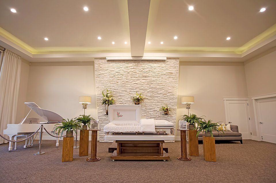 Spacious church sanctuary with white altar, grand piano, floral arrangements, and stone accent wall