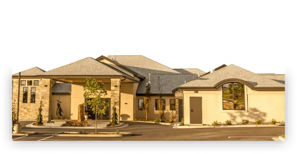 Large beige suburban house with stone accents and arched windows at sunset