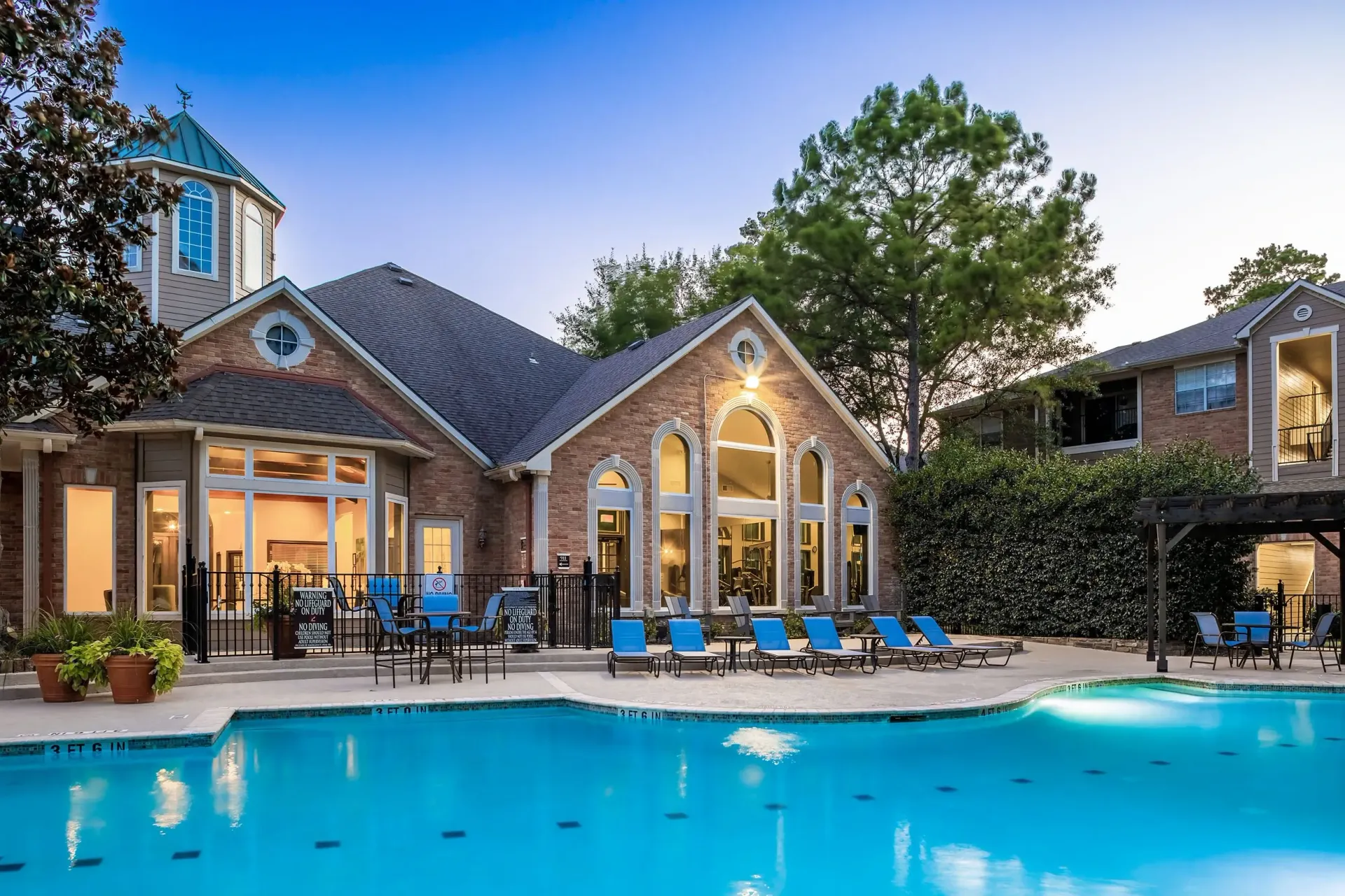 Resort-style swimming pool and lounge area with surrounding buildings.