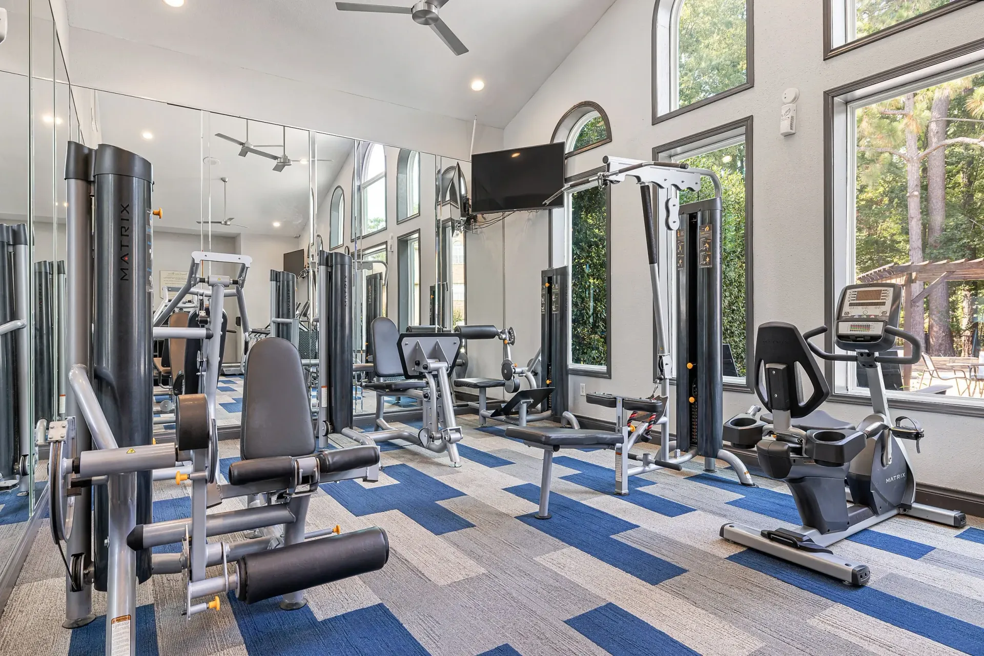 Fitness center with weight machines, treadmills, and large mirrors.