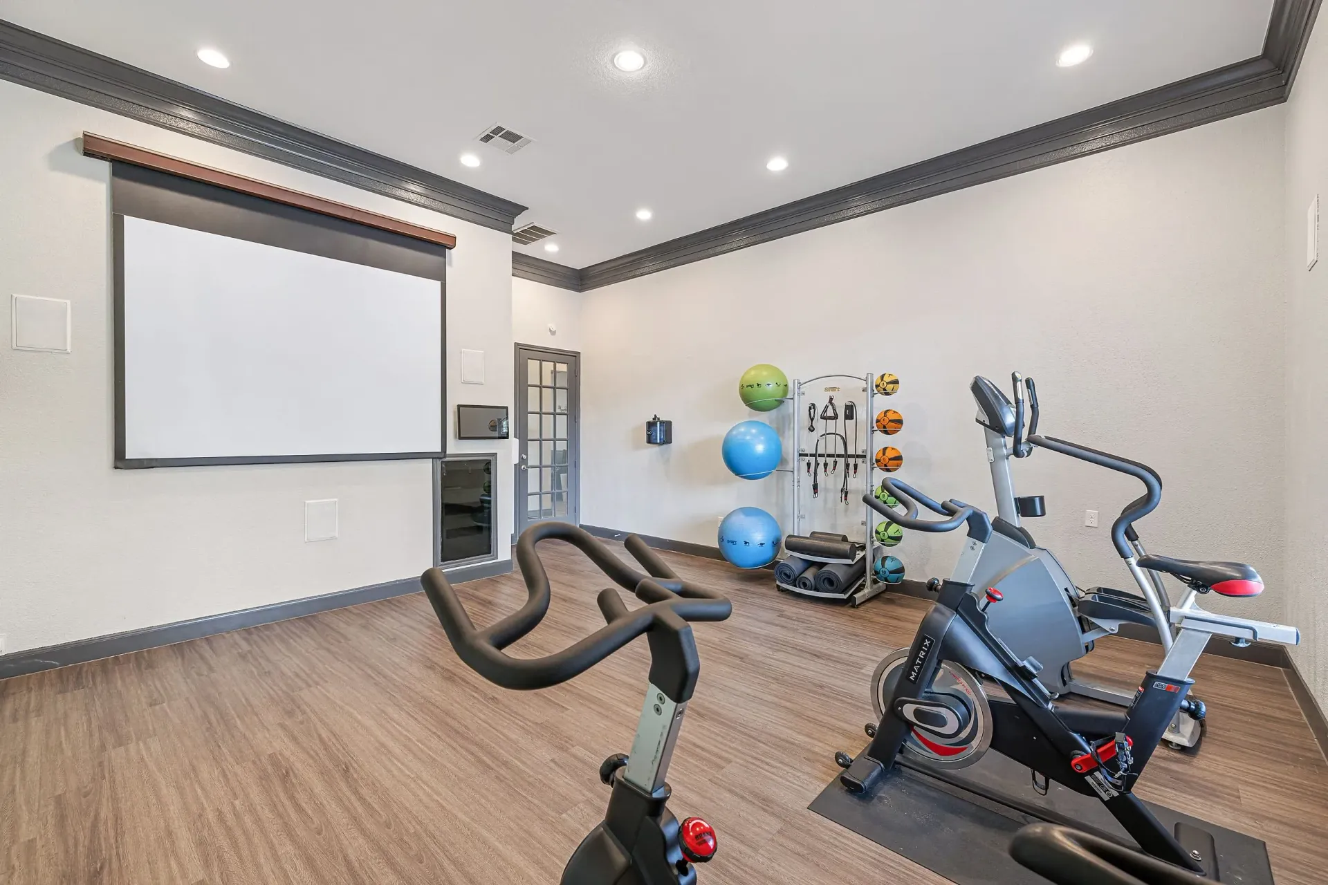 Gym area with stationary bikes, elliptical, and yoga balls.