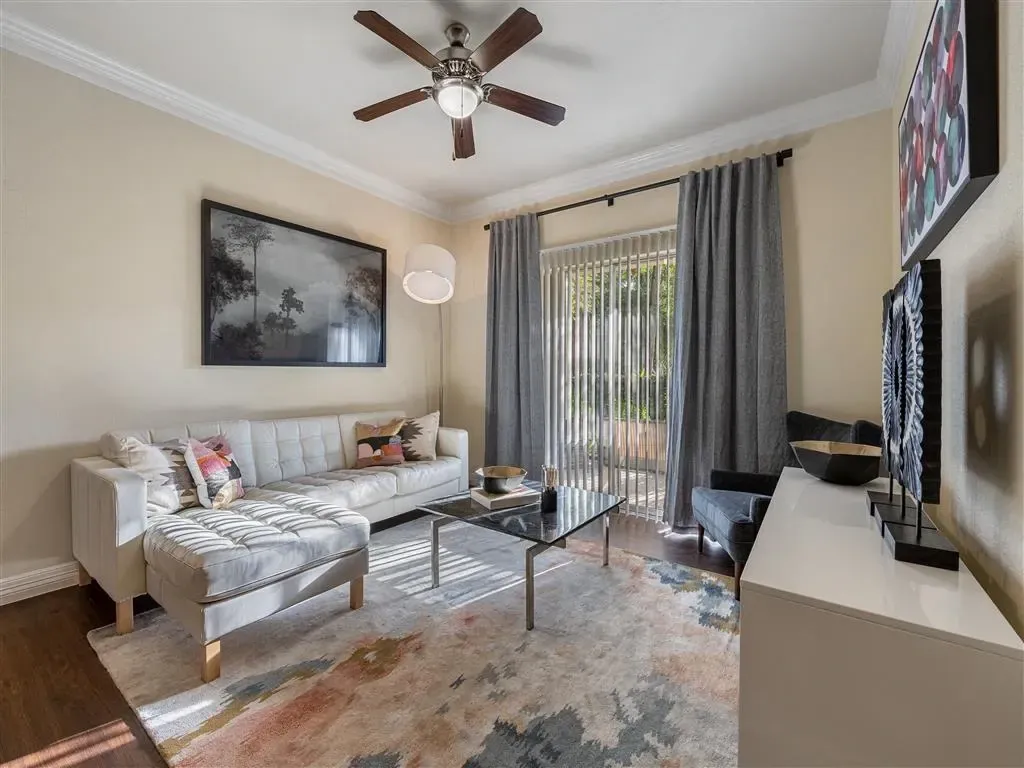 Modern living room with a white sectional sofa, coffee table, and large framed artwork.