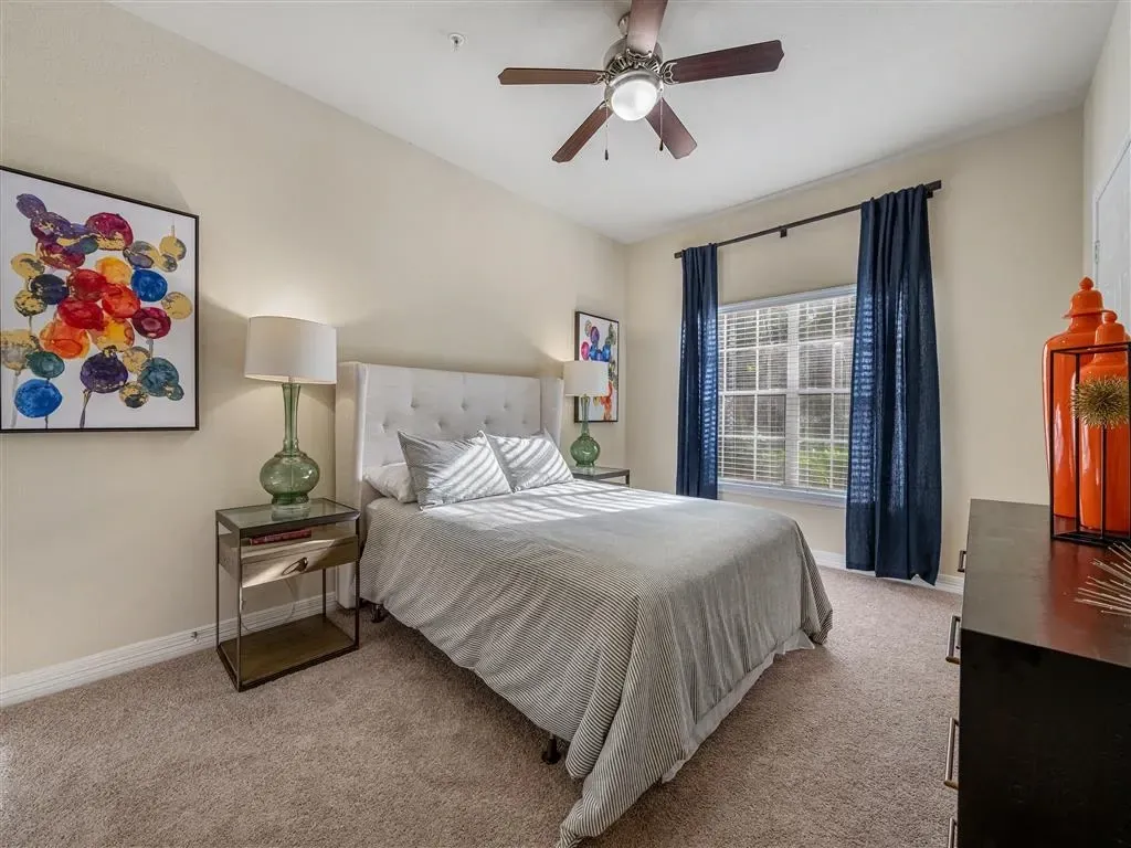 Bedroom with a queen-size bed, nightstand, dresser, and window.