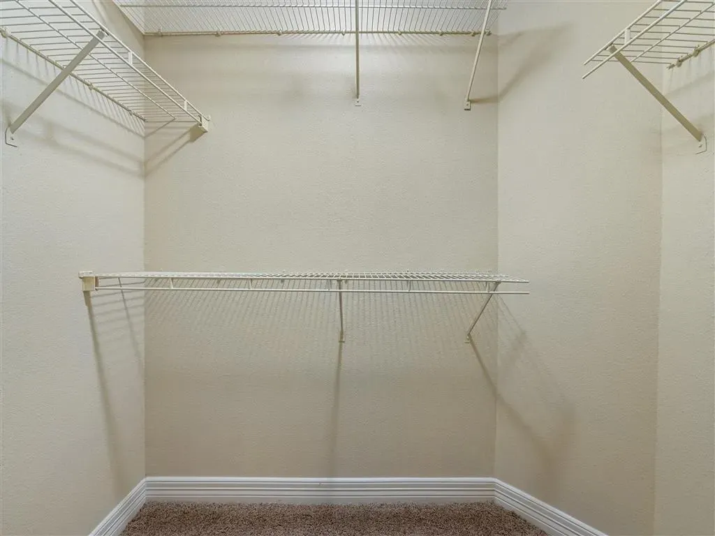 Empty walk-in closet with wire shelving.