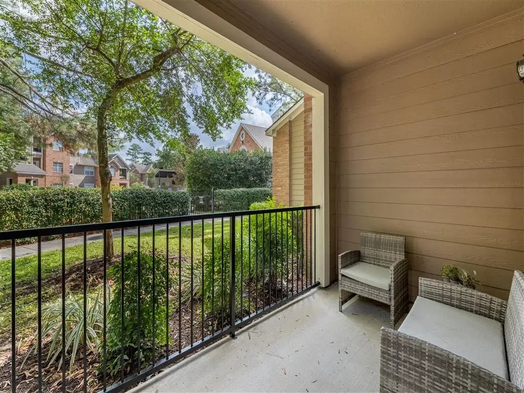 Balcony with seating and view of apartments and trees