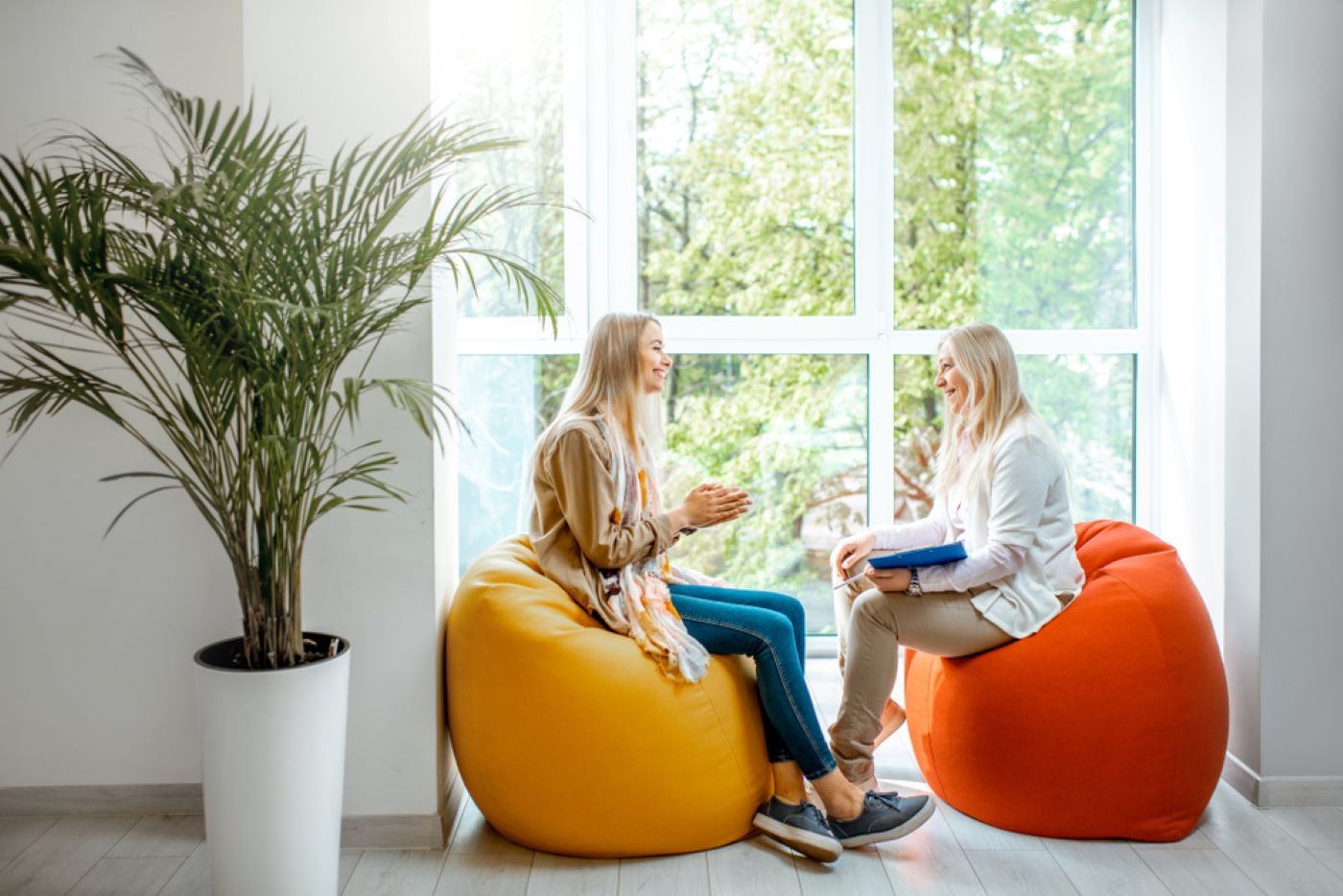 Two Women Are Sitting on Bean Bag Chairs — Moving Beyond OK In Marsden, QLD