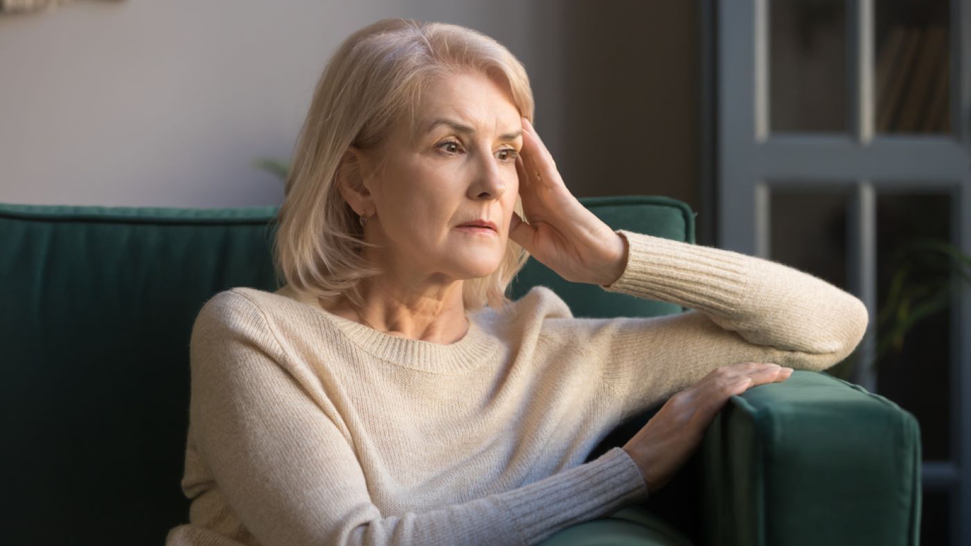 An Older Woman Is Sitting on A Couch — Moving Beyond OK In Marsden, QLD