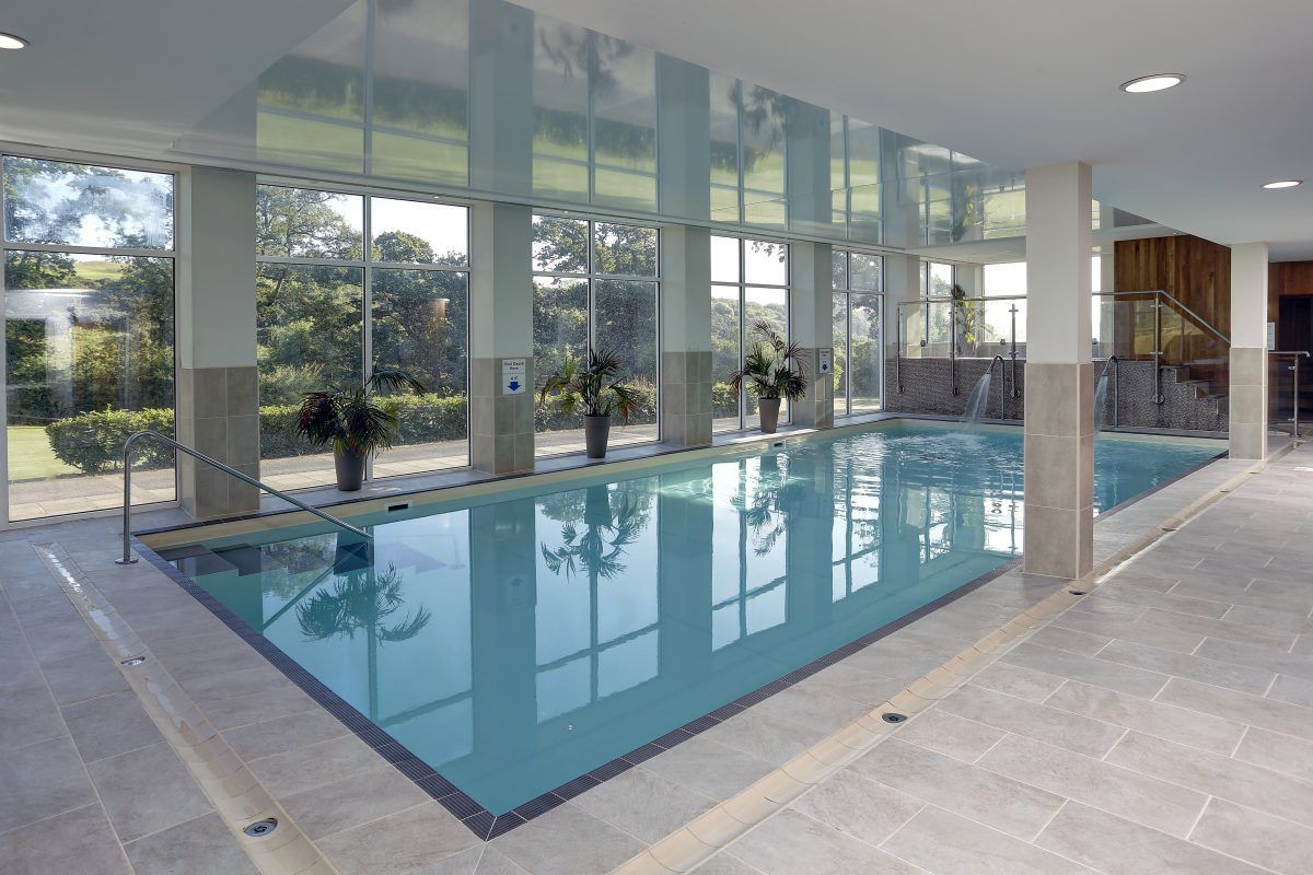 A large indoor swimming pool with a lot of windows