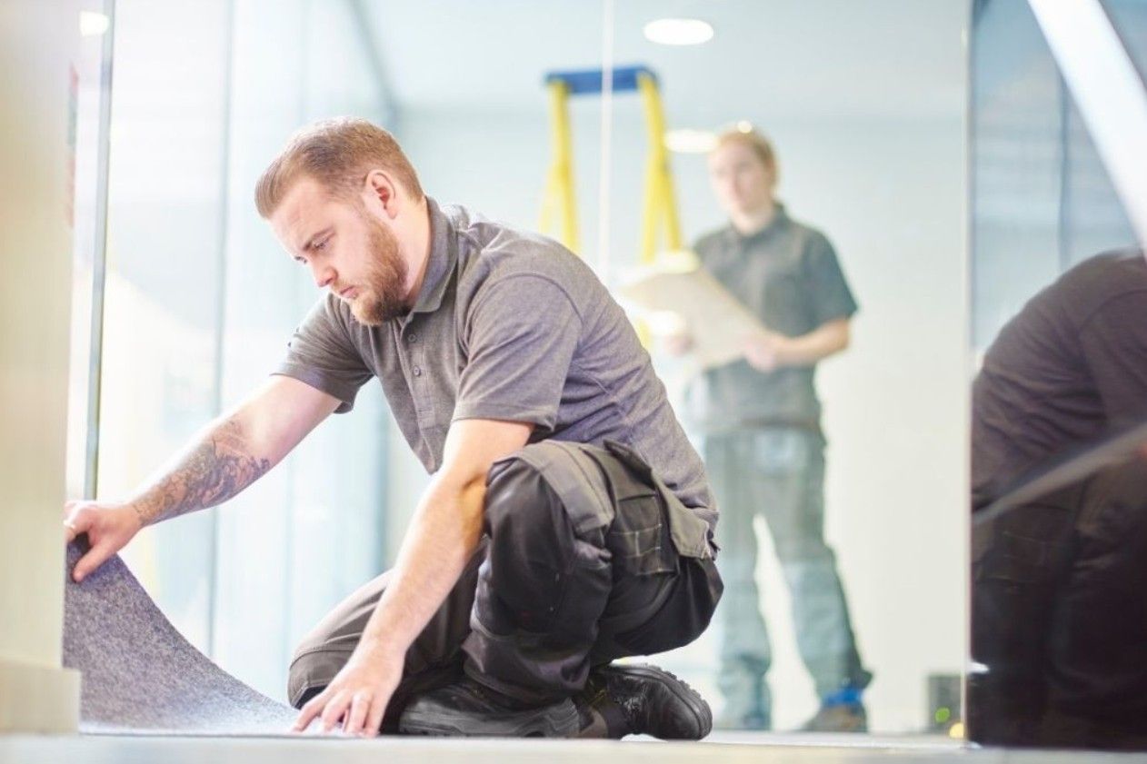 Professional flooring contractor fitting carpet tiles