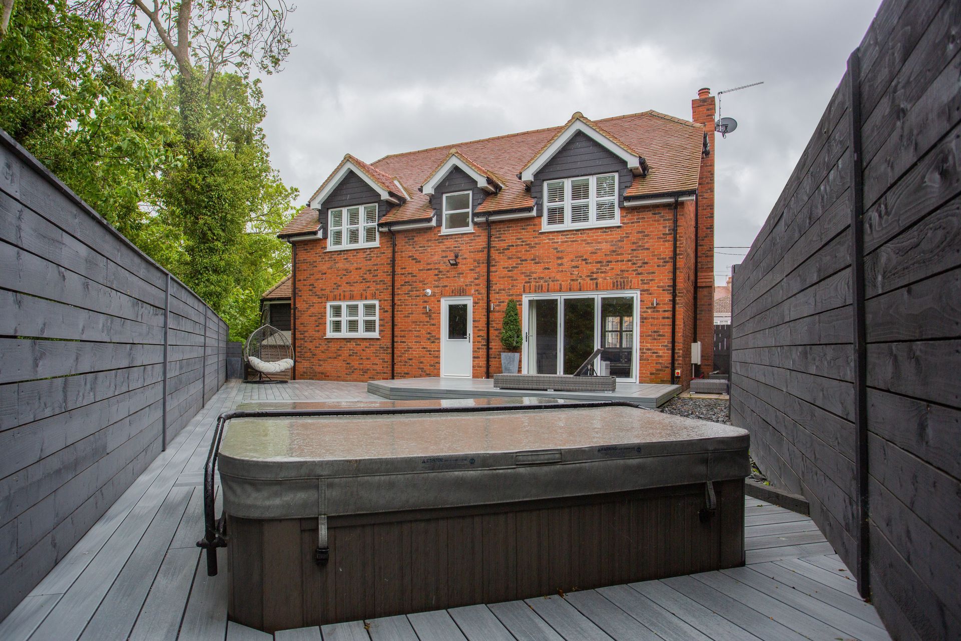 Brick house with a paved and decked rear garden