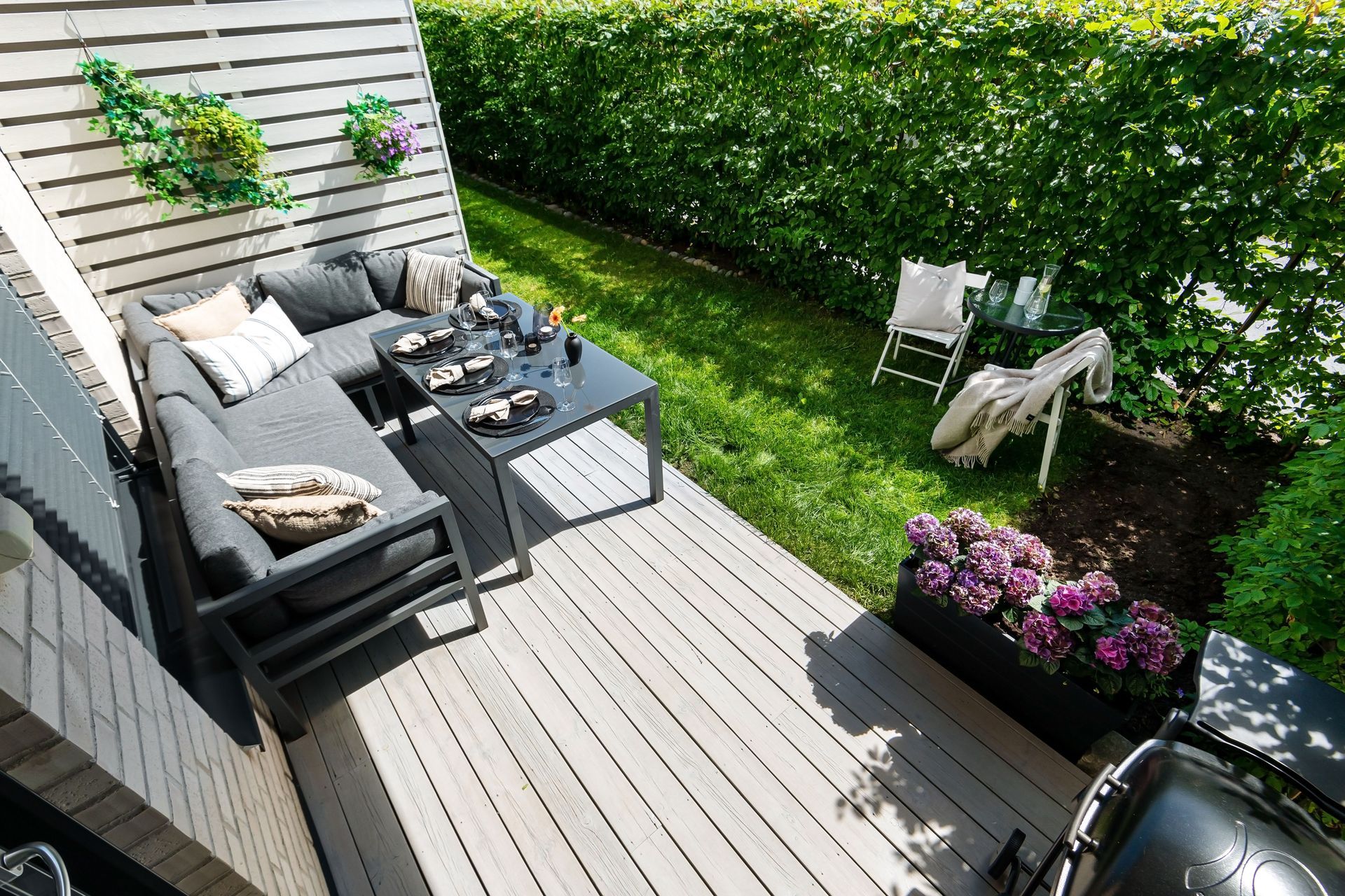 Garden deck with outdoor sofa beside a lawn