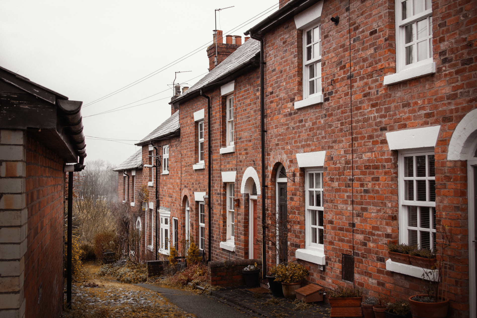 Row of red-brick terraced houses on a UK street
