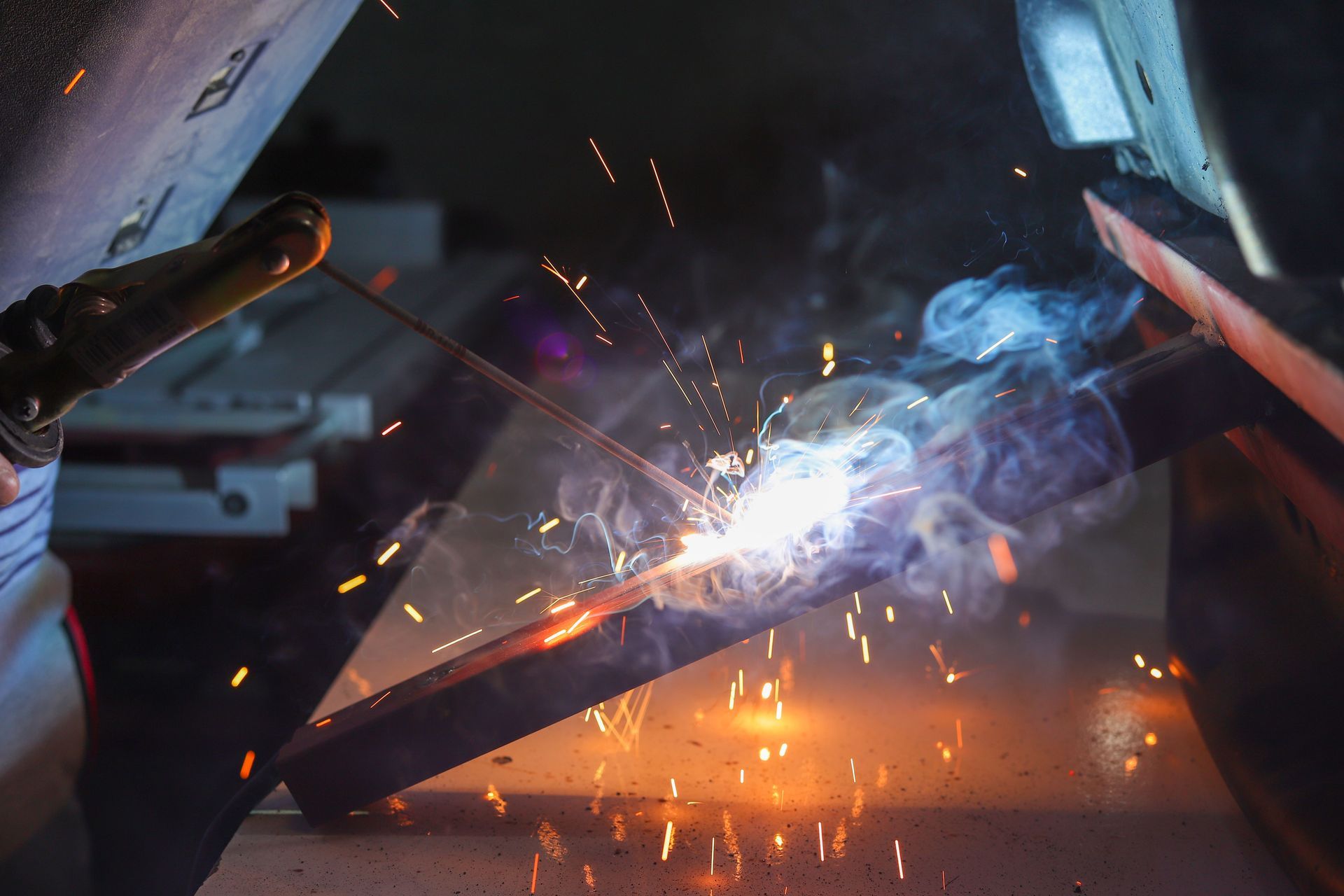 Welder working on steel with sparks flying