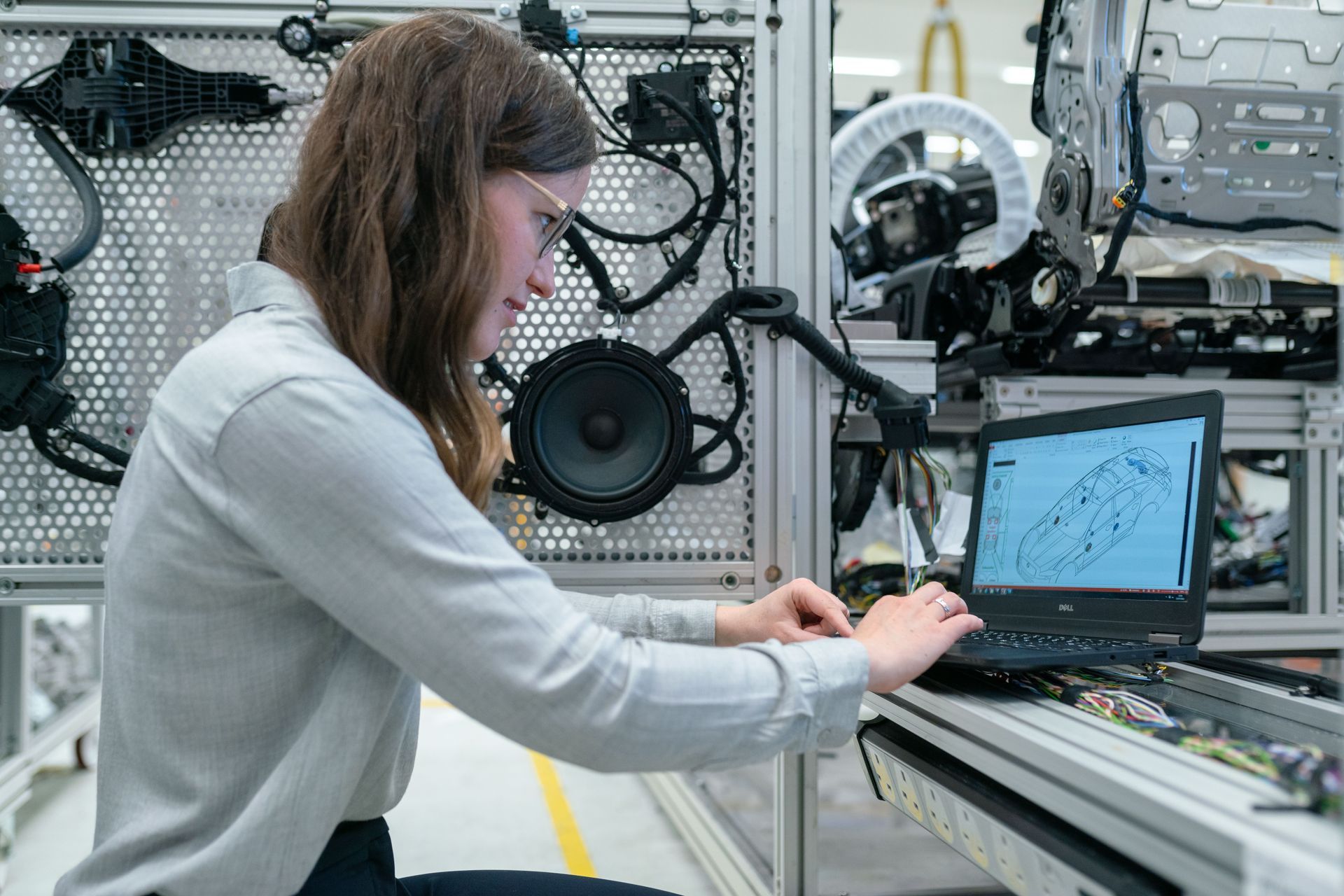 Engineer recording prototype test results on a laptop beside test equipment